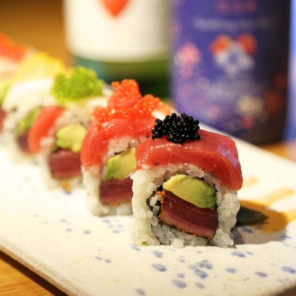 Sakanaya's colorful sushi rolls with tuna, avocado, and roe on a white plate.