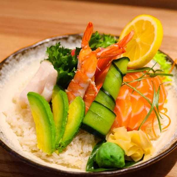 Sakanaya's chirashi bowl with salmon, shrimp, avocado, cucumber, and lemon over rice.